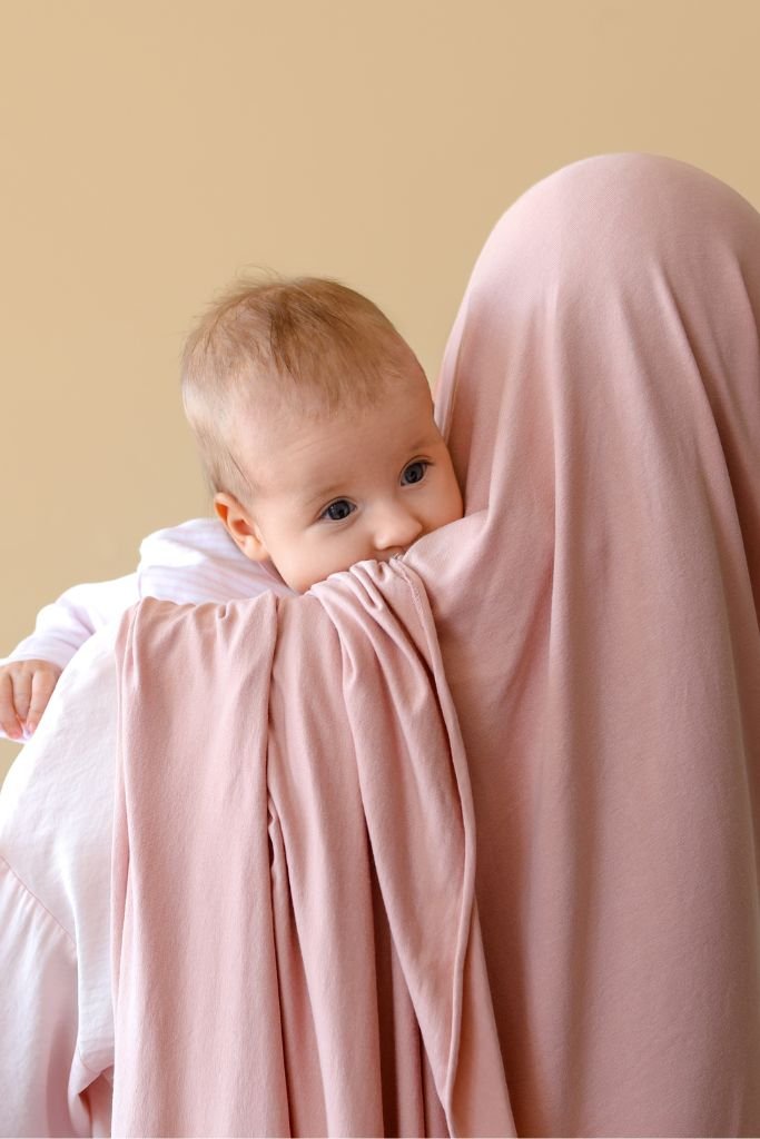 un bebe dans les bras de sa maman musulmane